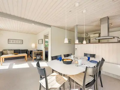 a dining room and living room with a table and chairs at Holiday Home Anja - 550m to the fjord by Interhome in Vemb