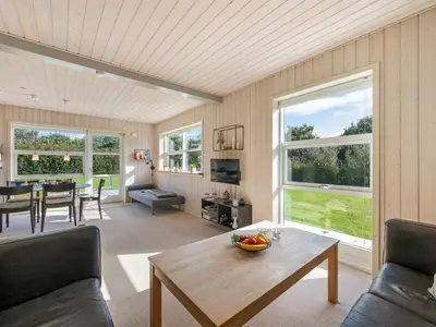 a living room with a table and chairs and windows at Holiday Home Anja - 550m to the fjord by Interhome in Vemb