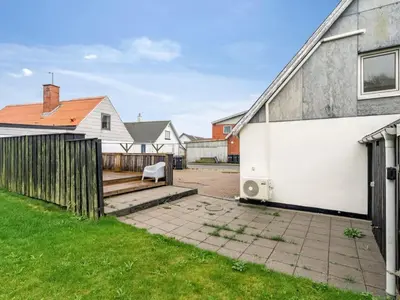 a house with a white wall and a fence at Holiday Home Raika - 25m to the fjord by Interhome in Vestervig
