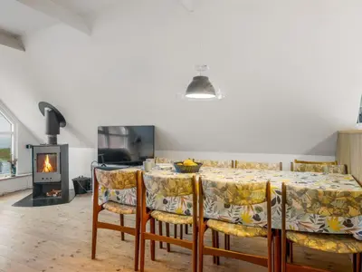 a dining room with a table and chairs and a fireplace at Holiday Home Raika - 25m to the fjord by Interhome in Vestervig