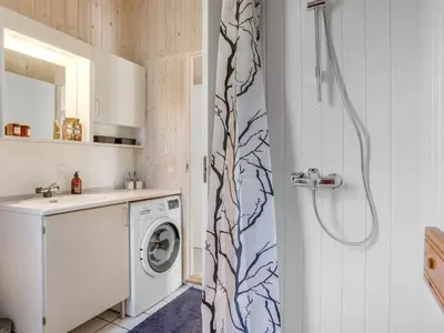 a bathroom with a shower with a washer and dryer at Holiday Home Marisol - 250m to the fjord by Interhome in Fur