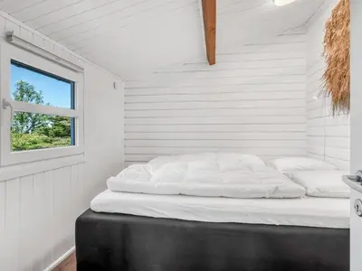 a bed in a room with a window at Holiday Home Berner - 500m to the fjord by Interhome in Roslev