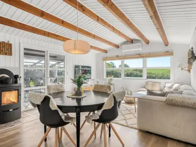 a kitchen and living room with a table and chairs at Holiday Home Berner - 500m to the fjord by Interhome in Roslev