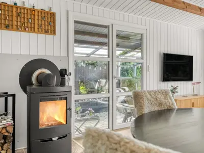 a living room with a stove and a table at Holiday Home Berner - 500m to the fjord by Interhome in Roslev