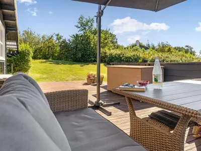 a patio with a table and chairs and an umbrella at Holiday Home Berner - 500m to the fjord by Interhome in Roslev