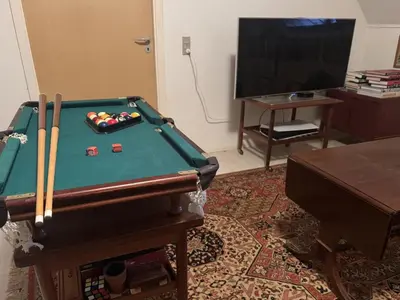 a living room with a pool table and a tv at Holiday Home Karmen - 1km from the sea by Interhome in Pandrup
