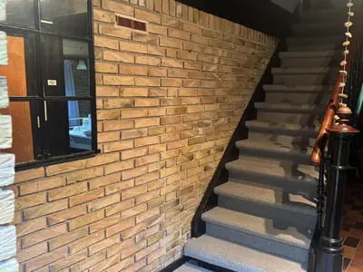 a staircase with a brick wall and a window at Holiday Home Karmen - 1km from the sea by Interhome in Pandrup