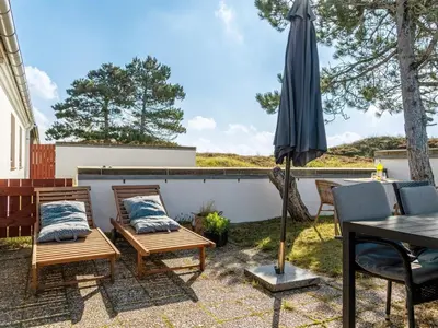a patio with a table and an umbrella at Apartment Enwald - 700m from the sea by Interhome in Pandrup