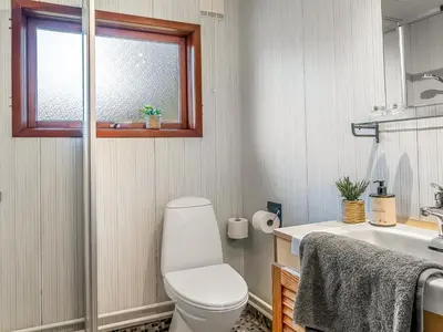 a bathroom with a toilet and a sink and a window at Holiday Home Anneka - 750m from the sea by Interhome in Pandrup