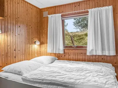 a bedroom with a bed and a window at Holiday Home Anneka - 750m from the sea by Interhome in Pandrup