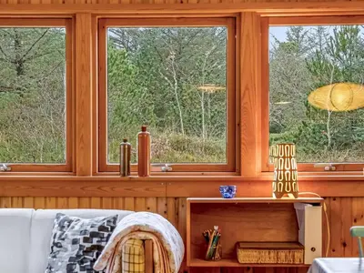 a living room with three windows and a couch at Holiday Home Anneka - 750m from the sea by Interhome in Pandrup