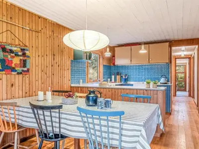 a kitchen with a table and chairs in a room at Holiday Home Anneka - 750m from the sea by Interhome in Pandrup