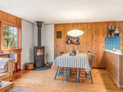 a dining room with a table and a fireplace at Holiday Home Anneka - 750m from the sea by Interhome in Pandrup