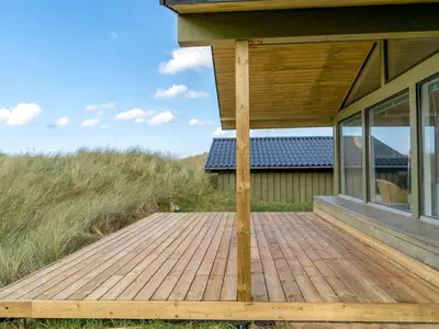 a wooden deck on the side of a house at Holiday Home Myrna - 250m from the sea by Interhome in Saltum