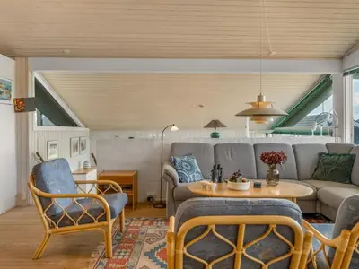 a living room with a couch and a table and chairs at Holiday Home Myrna - 250m from the sea by Interhome in Saltum