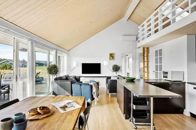 a kitchen and living room with a table and a couch at JB367-Brovst-Kronvildtvej-102 in Brovst