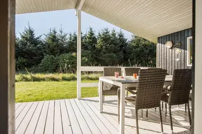 a patio with a table and chairs on a deck at LK2192-Lokken-Magdalenevej-18 in Løkken