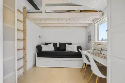 a small room with a bed and a table and chairs at LK2192-Lokken-Magdalenevej-18 in Løkken