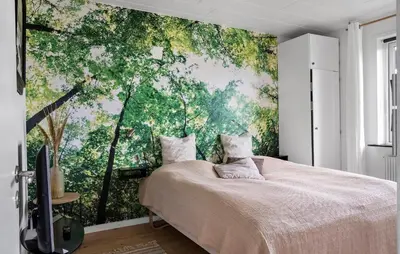 a bedroom with a large wall mural of trees at Awesome Home In Harboøre With Sauna in Harboør