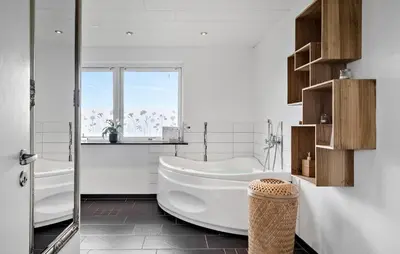a white bathroom with a tub and a window at Awesome Home In Harboøre With Sauna in Harboør