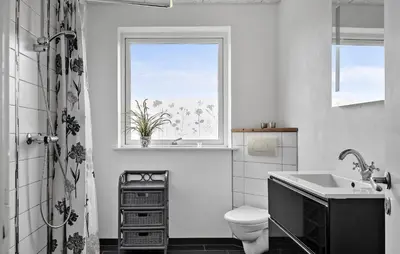 a bathroom with a sink and a toilet and a window at Awesome Home In Harboøre With Sauna in Harboør