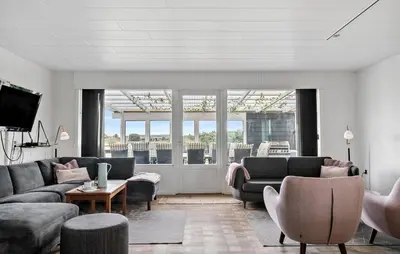 a living room with couches and chairs and a tv at Awesome Home In Harboøre With Sauna in Harboør