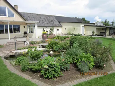 a garden in the front yard of a house at Bakkegården Homestay in Spottrup