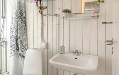 a white bathroom with a sink and a shower at Awesome Home In Farsø With Sauna in Farsø