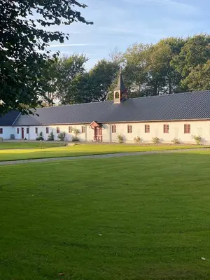 a large white barn with a large grass field at Staarup Hovedgaard in Højslev