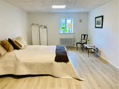 a bedroom with a large bed and a chair at Staarup Hovedgaard in Højslev