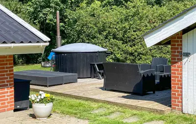 a backyard with a table and chairs and a gazebo at Ocean Front Home In Spøttrup With Sauna in Spottrup
