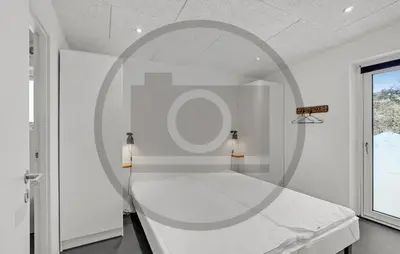 a white bedroom with a bed and a mirror at 4 Bedroom Awesome Home In Thyholm in Thyholm