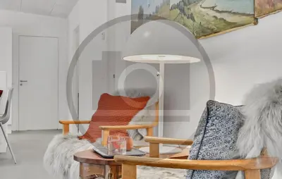 a living room with a chair and a mirror at 4 Bedroom Awesome Home In Thyholm in Thyholm