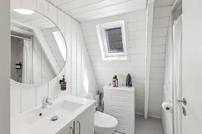a white bathroom with a sink and a toilet at Holiday Home At Himmerland Golf & Spa Resort in Farsø