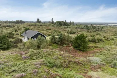a small house in the middle of a field at Family House With Sea View In Svinkløv in Fjerritslev