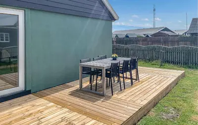 a wooden deck with a table and chairs on it at Lovely Home In Thyborøn With Wifi in Thyborøn