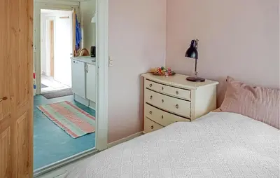 a bedroom with a bed and a dresser and a mirror at Lovely Home In Thyborøn With Wifi in Thyborøn