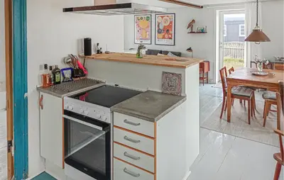 a kitchen with a stove top oven next to a table at Lovely Home In Thyborøn With Wifi in Thyborøn