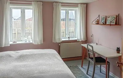 a bedroom with a bed and a desk and windows at Lovely Home In Thyborøn With Wifi in Thyborøn