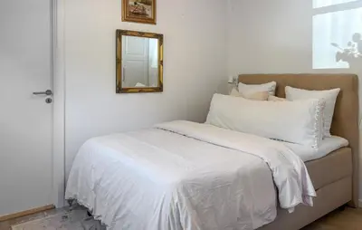 a bed with white sheets and a mirror on the wall at Gorgeous Home In Farsø With Wifi in Farsø