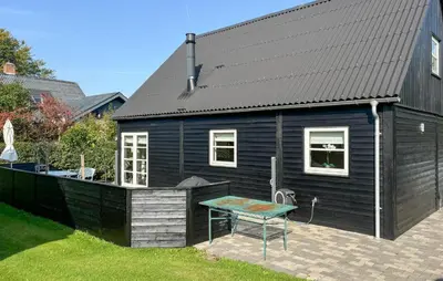 a black house with a picnic table in the yard at Gorgeous Home In Farsø With Wifi in Farsø
