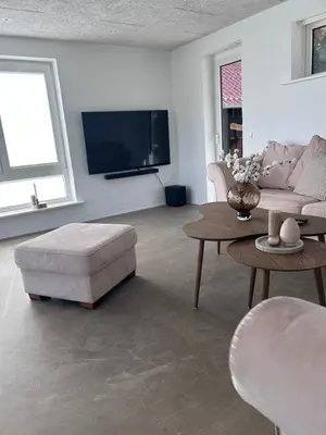 a living room with a couch and a table and a tv at Udsigtsvilla Tambohus in Thyholm