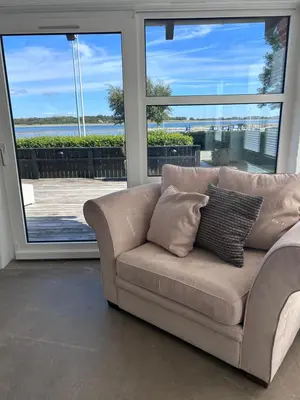 a couch in a living room with a large window at Udsigtsvilla Tambohus in Thyholm