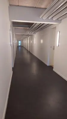 an empty room with a long hallway in an office building at Antonia s quality apartment 1 in Viborg