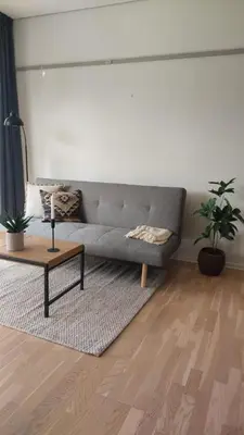 a living room with a gray couch and a table at Antonia s quality apartment 1 in Viborg