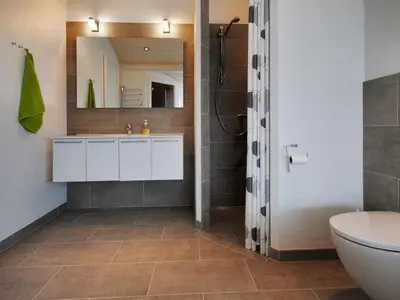 a bathroom with a sink and a toilet and a mirror at Holiday Home Arisa - 100m to the fjord by Interhome in Løgstør