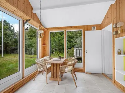 a dining room with a table and chairs and windows at Holiday Home Elea - 450m to the fjord by Interhome in Vemb