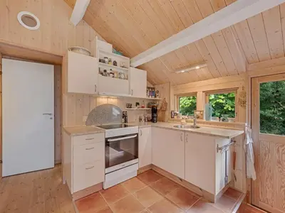 a kitchen with white cabinets and a wooden ceiling at Holiday Home Elea - 450m to the fjord by Interhome in Vemb