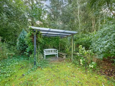 a bench under a pergola in a garden at Holiday Home Elea - 450m to the fjord by Interhome in Vemb