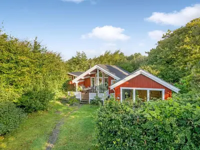 a red house in the woods with a yard at Holiday Home Elea - 450m to the fjord by Interhome in Vemb